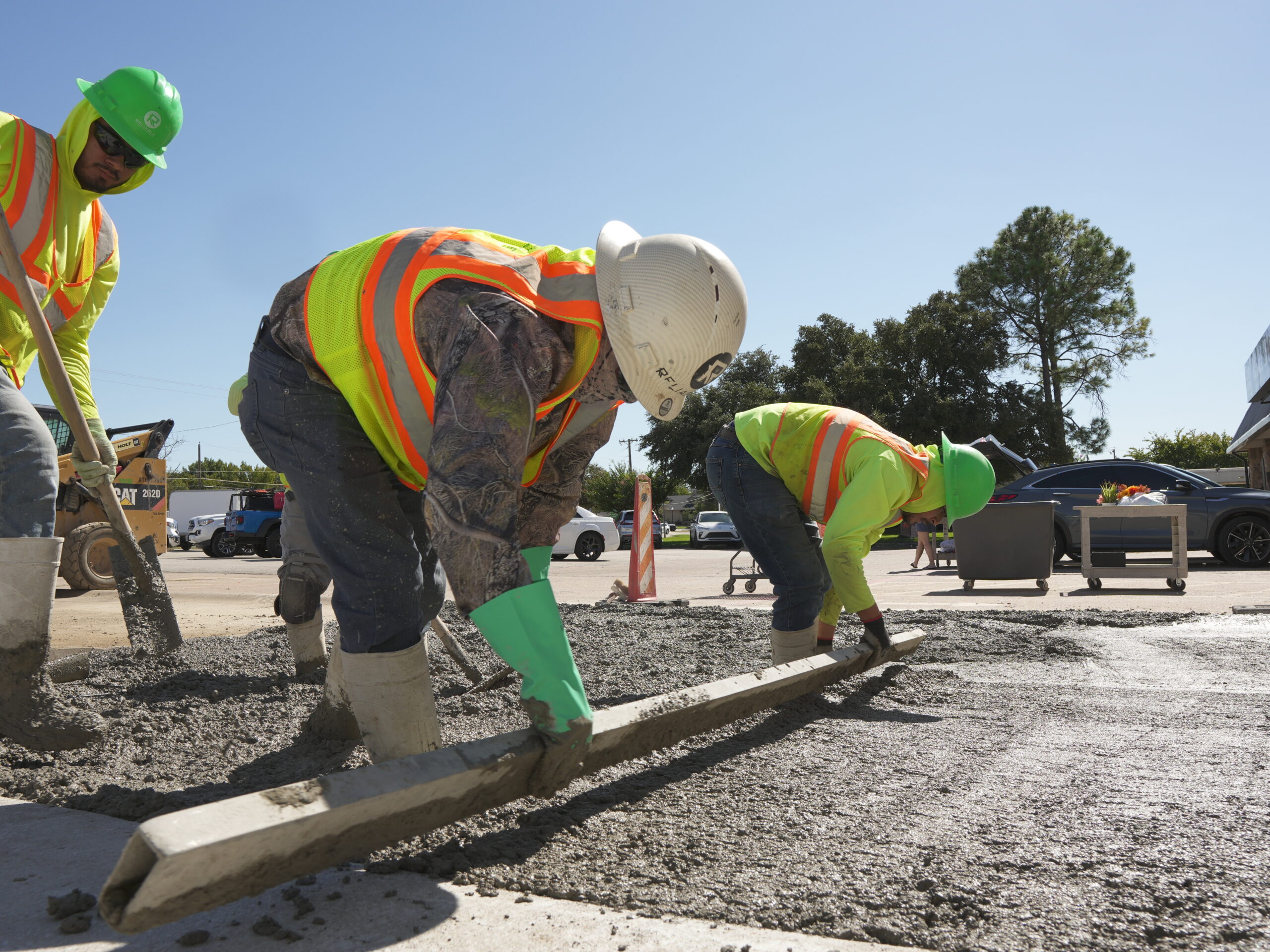 Reliable Paving crew hand-finishing a concrete parking lot pour in North Texas