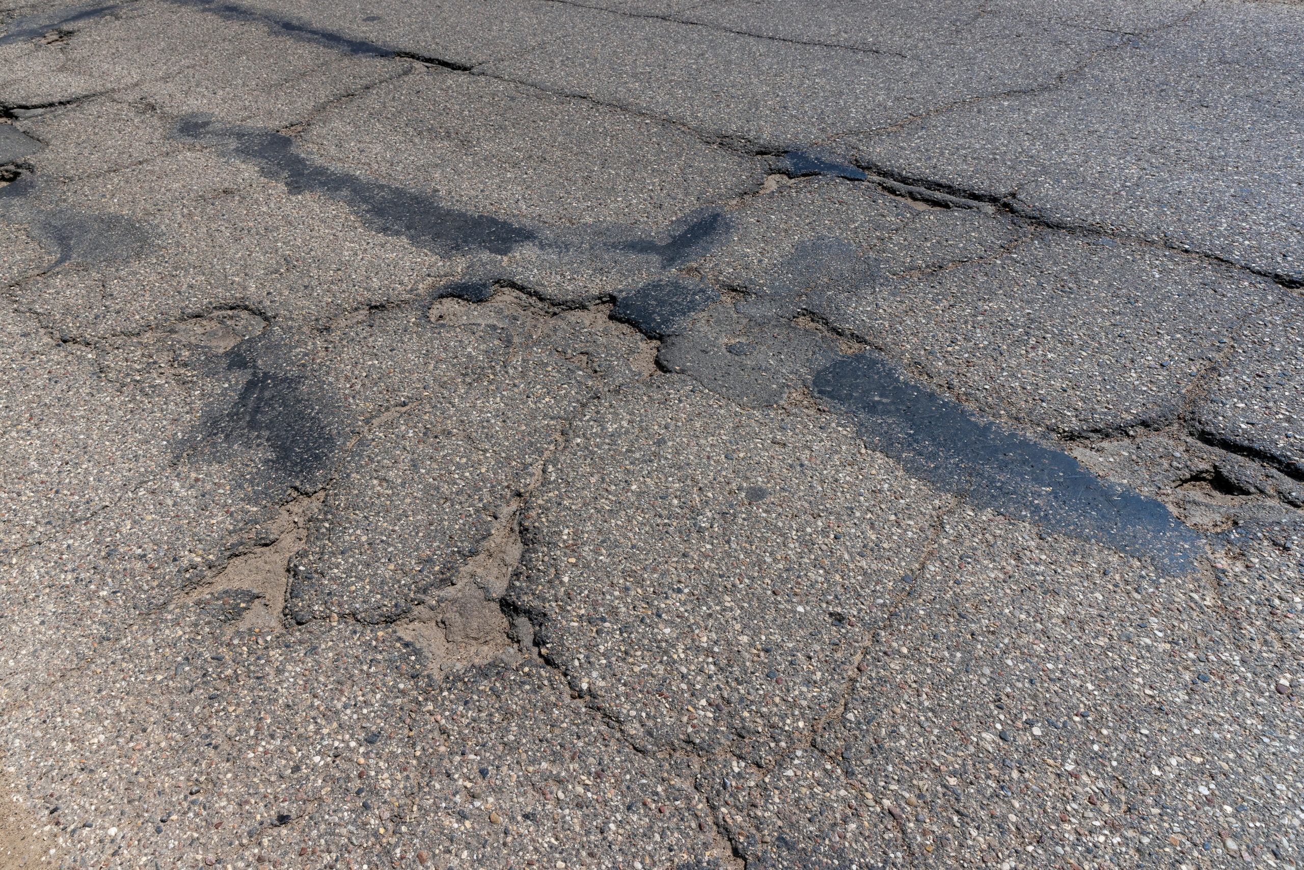 Close-up of deep alligator cracking on a deteriorated commercial parking lot