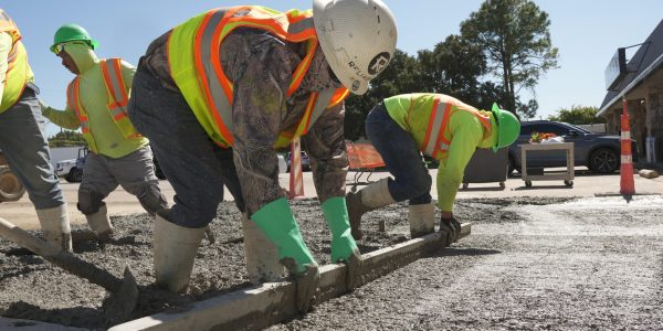 Reliable Paving crew finishing a fresh concrete pour on a commercial parking lot in Texas